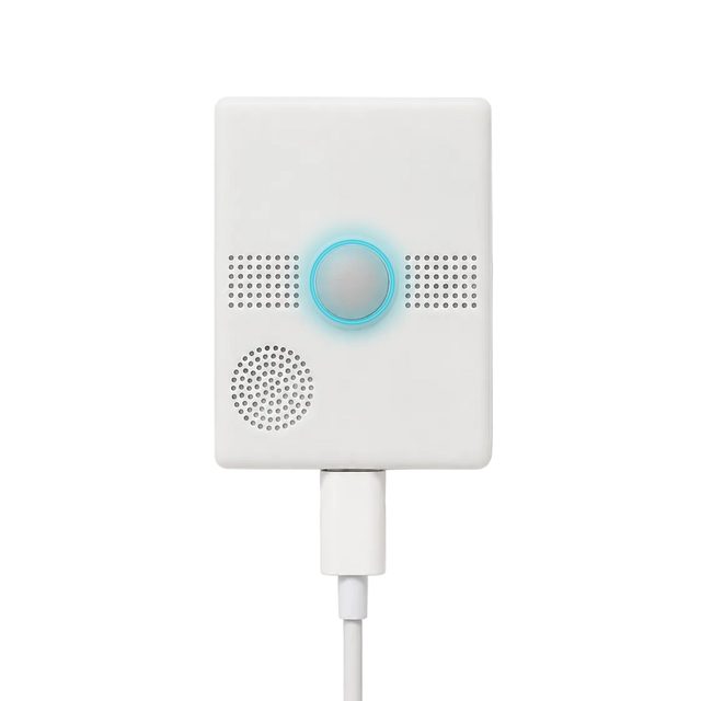 The white NxHUB device with its round button and microphone grilles